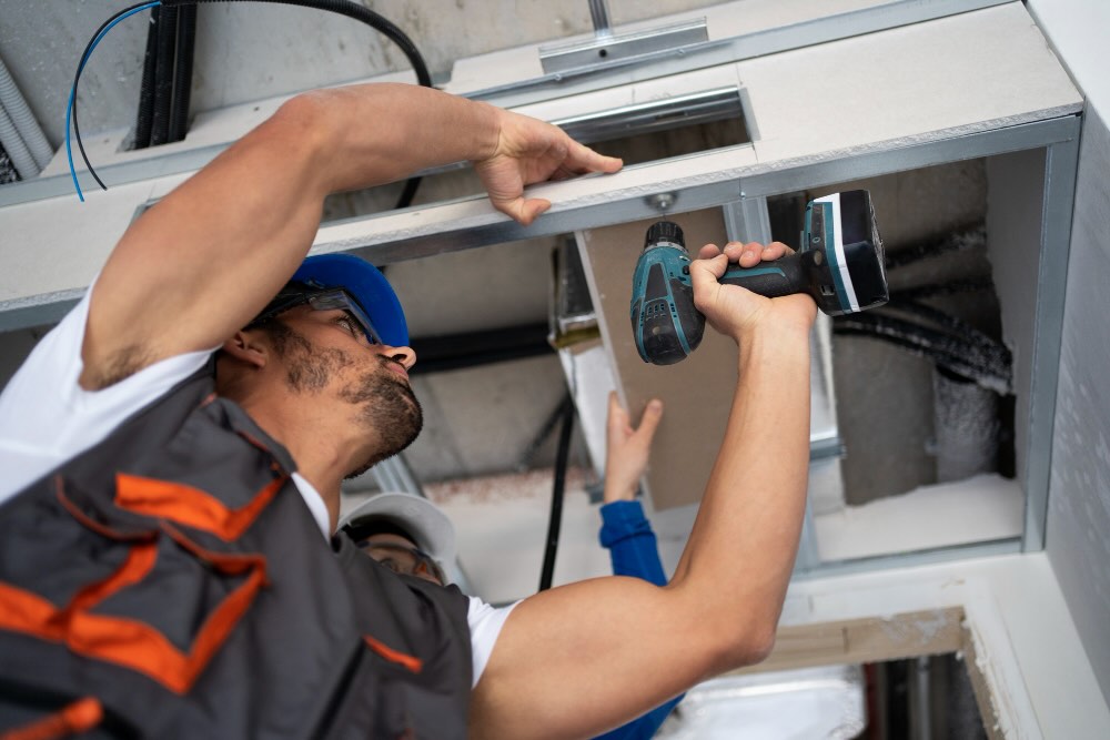 Maintenance technician repairing Hotel Air Conditioner Maintenance staff fixing a broken light in a vacation rental room